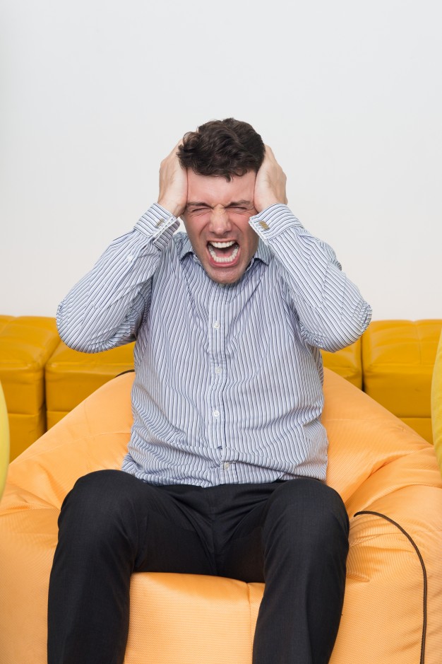 mad-young-man-sitting-beanbag-office-crying_1262-1013